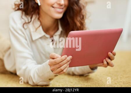 Horizontale mittlere Nahaufnahme von Freiberuflerin, die ihren Job mit einem modernen pinken Tablet-Computer erledigt Stockfoto