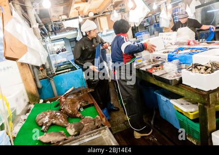 Tokio, Japan - 15. Januar 2010: Anbieter schneidet Fisch auf dem Tsukiji Fischmarkt. Am frühen Morgen auf dem Fischmarkt. Stockfoto