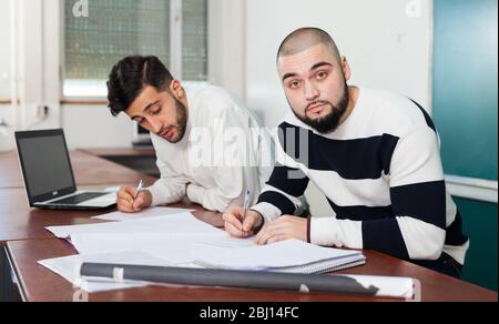 Porträt von zwei junge Kerle, die auf Ihren studentisches Projekt am Schreibtisch im Klassenzimmer Stockfoto