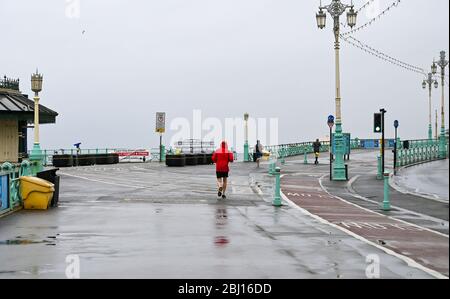 Brighton UK 28. April 2020 - EINIGE Läufer haben viel Platz entlang der Küste von Brighton, da kaltes nasses Wetter nach wochenlangem Sonnenschein während der Sperrbeschränkungen in Großbritannien angekommen ist, während die Pandemie-Krise des Coronavirus COVID-19 andauert. Quelle: Simon Dack / Alamy Live News Stockfoto