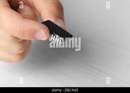 Männliche Finger halten Mikrochip isoliert auf weiß Stockfoto