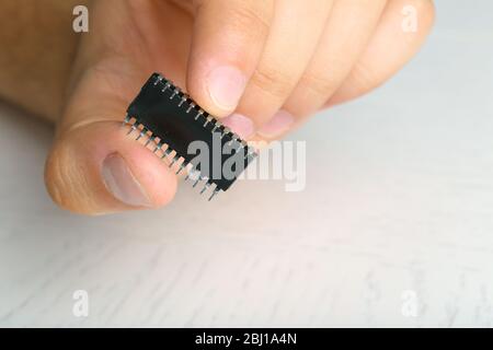 Männliche Finger halten Mikrochip isoliert auf weiß Stockfoto