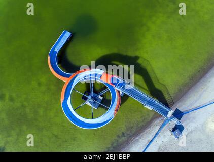 28. April 2020, Mecklenburg-Vorpommern, Bützow: Die leere Wasserrutsche steht am Ufer des Großen Rühner Sees im Freischwimmbad. (Luftaufnahme mit Drohne) aufgrund von Korona-Schutzmaßnahmen sind die Freibäder in Mecklenburg-Vorpommern geschlossen. Die Landesregierung will heute weitere Entscheidungen treffen, um Schritte aus der Blockierung der Korona zu Unternehmen. Für die bereits angekündigte Rückkehr von Zweitwohnheimbesitzern aus anderen Staaten nach MV und von Dauercampern zu den Plätzen ab dem 1. Mai sollen die notwendigen Regelungen verabschiedet werden. Foto: Jens Büttner/dpa-Zentralbild/dpa Stockfoto