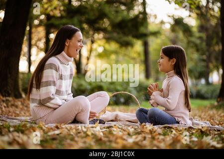 Mutter und Tochter genießen Herbst im Park. Stockfoto