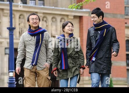 Eine Gruppe ausländischer (chinesischer) Studenten geht über den Campus der Universität Birmingham, England, Großbritannien. Stockfoto