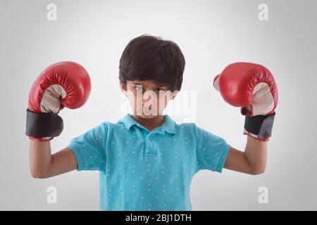 Porträt eines jungen Jungen mit Boxhandschuhen Stockfoto