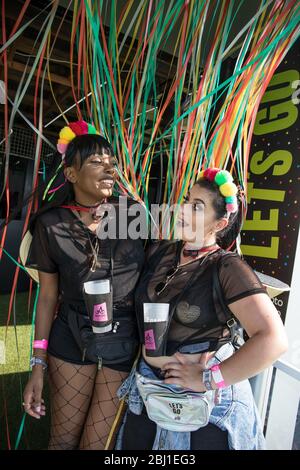 Zwei Freundinnen lächeln für die Kamera beim Musikfestival EDP Nos Alive, in Alges, Lissabon, Portugal. Stockfoto