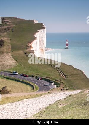 Beachy Head, die South Downs, England. Wanderer wandern auf dem South Downs Way vorbei an der weißen Kalkfelse von Beachy Head und ihrem Leuchtturm. Stockfoto