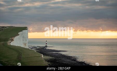 Sonnenaufgang in Beachy Head, England. Ein Blick am frühen Morgen über die East Sussex South Downs in den Ärmelkanal mit seinem Wahrzeichen Leuchtturm. Stockfoto