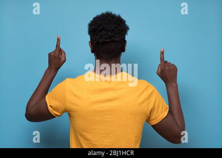 Rückansicht des afrikanischen Mannes, der Ihre Aufmerksamkeit auf wichtige Informationen lenkt. Stockfoto