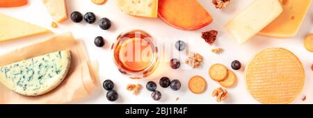 Käse und Wein Verkostung und Paarung flach legen Panorama auf einem weißen Hintergrund mit einem Ort für Text. Viele verschiedene Käsesorten, von oben geschossen Stockfoto