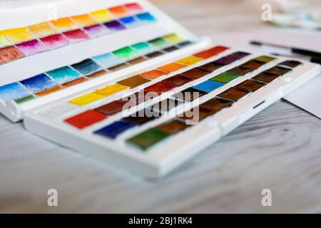 Öffnen Sie Aquarellfarben Palette, Pinsel auf Holztisch. Nahaufnahme, ausgewählter Fokus. Stockfoto