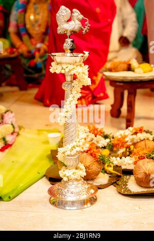 Traditionelle silberne Öllampe brennt bei einer südindischen Hindu-Hochzeit Stockfoto