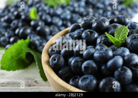 Leckere reife Heidelbeeren mit Minze in Schale auf dem Tisch aus nächster Nähe Stockfoto