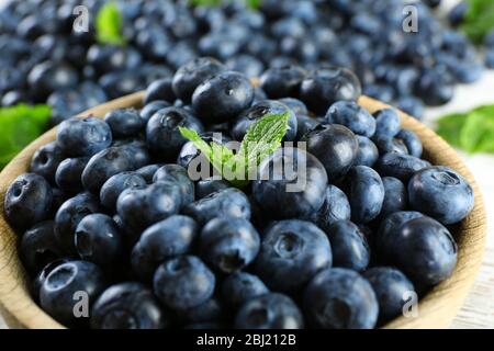 Leckere reife Heidelbeeren mit Minze in Schale auf dem Tisch aus nächster Nähe Stockfoto