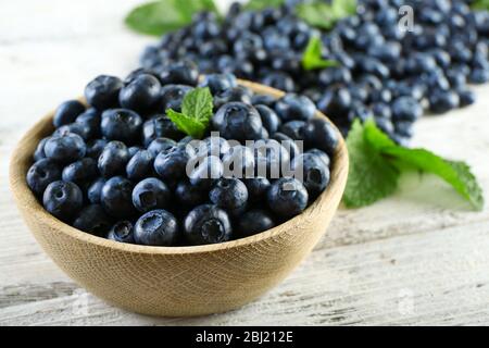 Leckere reife Heidelbeeren mit Minze in Schale auf dem Tisch aus nächster Nähe Stockfoto