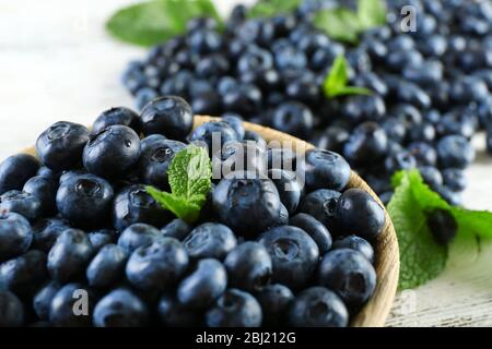 Leckere reife Heidelbeeren mit Minze in Schale auf dem Tisch aus nächster Nähe Stockfoto