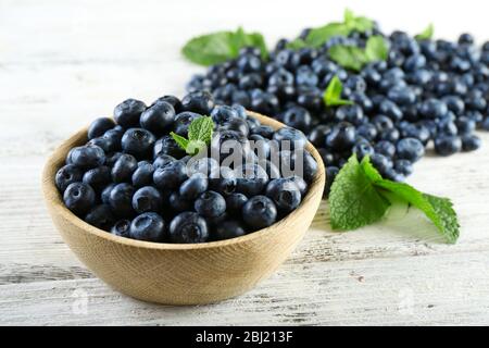 Leckere reife Heidelbeeren mit Minze in Schale auf dem Tisch aus nächster Nähe Stockfoto