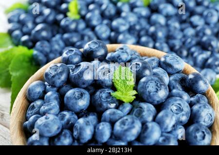 Leckere reife Heidelbeeren mit Minze in Schale auf dem Tisch aus nächster Nähe Stockfoto