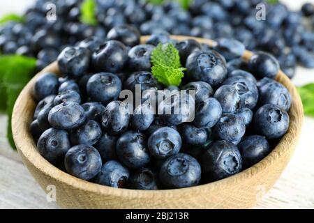 Leckere reife Heidelbeeren mit Minze in Schale auf dem Tisch aus nächster Nähe Stockfoto