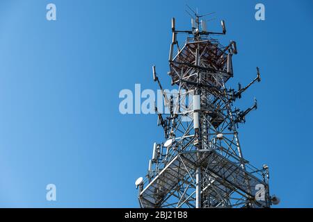 Oben auf dem Mobilfunkturm gegen blauen Himmel. Antenne für Mobiltelefone Telekommunikation verwendet. Stockfoto