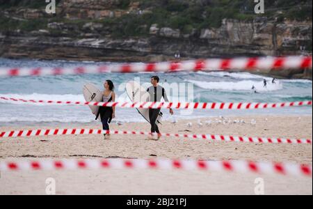 Sydney, Australien. April 2020. Surfer laufen am Bondi Beach in Sydney, Australien, am 28. April 2020. Hunderte von Aussies strömten am Dienstag zum Wasser, als der berühmte Bondi Beach nach der COVID-19 für Surfer und Schwimmer wieder geöffnet wurde. Kredit: Bai Xuefei/Xinhua/Alamy Live News Stockfoto