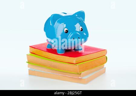 Sparschwein über einem Stapel von bunten Büchern Stockfoto