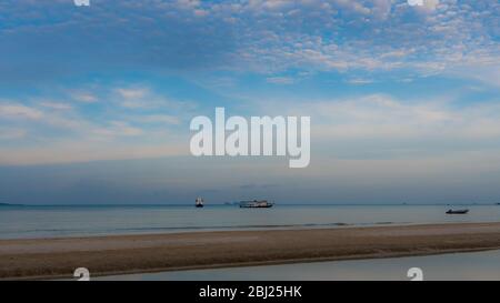 Boote vor Anker in ruhiger See vor dem Strand in Thailand mit Sandbank und Gezeitenbecken im Vordergrund Stockfoto