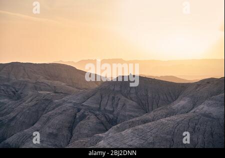 Bizarr übereinander geschichteten Berge und Schluchten bei Sonnenuntergang in der Wüste park Altyn Emel in Kasachstan Stockfoto