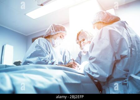 Ein Team von Ärzten kämpft um das Leben des Patienten. Intensivstation, Kampf gegen Viren und Bacretria, Covid 19. Lungenentzündung ist Stockfoto