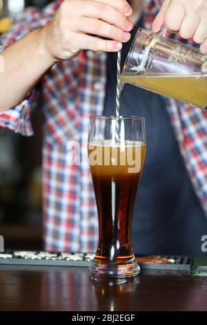 Der Barkeeper gießt Bier ins Glas Stockfoto