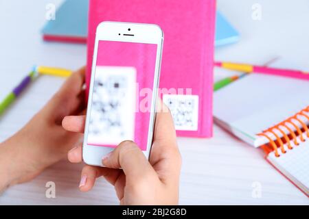 Frau scannt Gutschein-Code mit Handy aus nächster Nähe Stockfoto