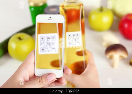 Frau scannt Gutschein-Code mit Handy aus nächster Nähe Stockfoto