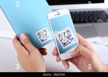 Frau scannt Gutschein-Code mit Handy aus nächster Nähe Stockfoto