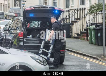 Eastbourne, England. 28 April 2020. Polizist mit ausziehbarer Leiter verlässt das überfallen Eigentum. Quelle: Antony Meadley/Alamy Live News Stockfoto