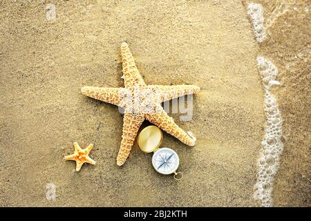Kompass mit Seesternen auf Sand Strand Hintergrund Stockfoto