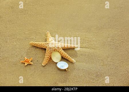 Kompass mit Seesternen auf Sand Strand Hintergrund Stockfoto