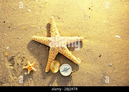 Kompass mit Seesternen auf Sand Strand Hintergrund Stockfoto