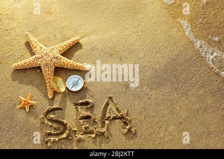 Kompass mit Seesternen auf Sand Strand Hintergrund Stockfoto