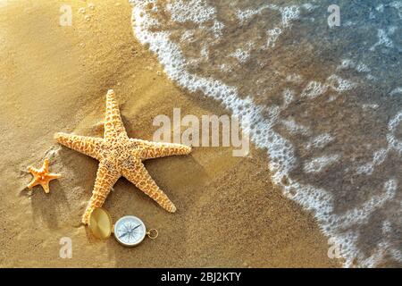 Kompass mit Seesternen auf Sand Strand Hintergrund Stockfoto