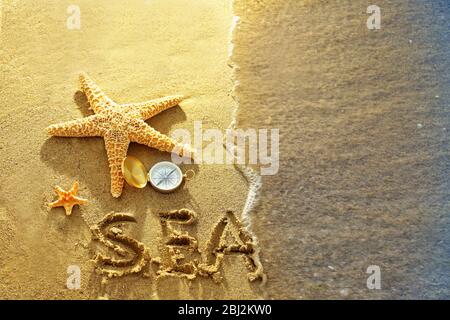 Kompass mit Seesternen auf Sand Strand Hintergrund Stockfoto