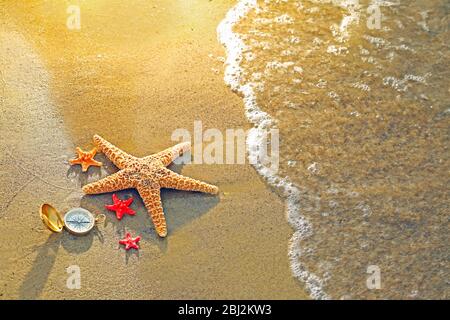 Kompass mit Seesternen auf Sand Strand Hintergrund Stockfoto