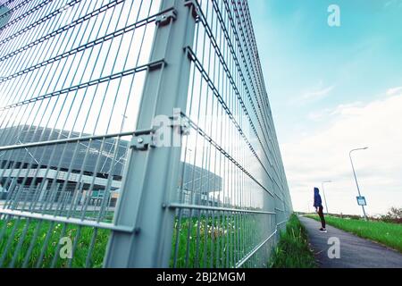 Traurig Thoughtful Teenager Hipster Mädchen allein vor dem Metall-Gitter stehen Stockfoto