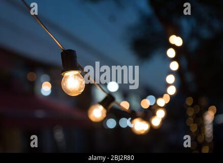 Eine Reihe von Glühlampen in der Straße und Bokeh. Stockfoto