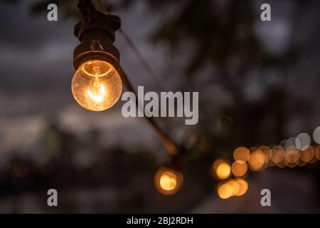 Eine Reihe von Glühlampen in der Straße und Bokeh. Stockfoto