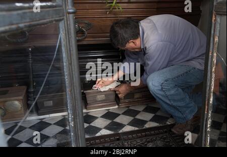 Buenos Aires, Argentinien - Mai 03 2016: Angestellter des recoleta Friedhofs, der eine Urne in einem Gewölbe säubert. Stockfoto