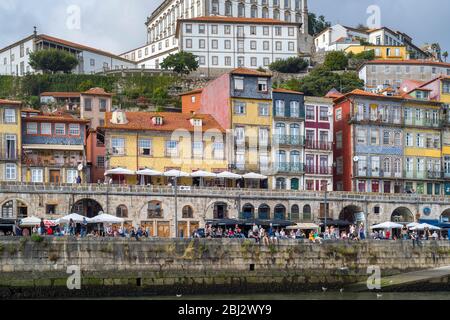 Häuser und Cafés mit Balkon in hellen Farben in Ribeira am Fluss Douro in Porto, Portugal Stockfoto