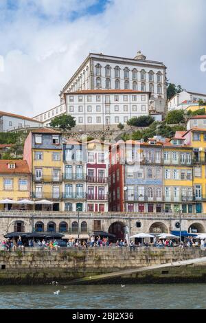 Bunte Häuser und Cafés mit Balkon in hellen Farben am Fluss Ribeira am Douro in Porto, Portugal Stockfoto