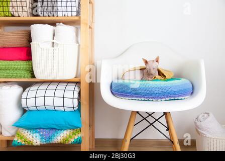 Bettwäsche, Bettbezüge und Handtücher werden vertikal gefaltet. Körbe aus Metall und Stoff schwarz. Bettwäsche in hellen Farben. Stockfoto