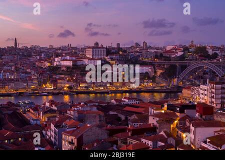 Historische Flussfront der Ribeira Region von Porto bei Dämmerung und Dom Luis I Brücke von Vila Nova de Gaia in Portugal Stockfoto